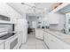 Cozy white kitchen featuring modern appliances and open to the adjoining living area for easy entertaining at 7048 Inland St, Englewood, FL 34224
