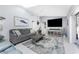 Inviting living room with a plush gray sofa, stylish rug, and a large-screen TV for entertainment at 7048 Inland St, Englewood, FL 34224