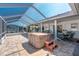 Inviting screened patio featuring a hot tub, seating area, and seamless access to outdoor relaxation and entertainment at 7048 Inland St, Englewood, FL 34224