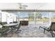 Relaxing screened patio features a hot tub, dining table, ceiling fan, and outdoor seating area at 7048 Inland St, Englewood, FL 34224