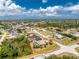 Aerial view of a single-Gathering home featuring a screened pool, lush greenery, and a well-kept lawn at 7247 Brookhaven Ter, Englewood, FL 34224