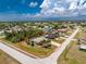 Aerial view of property including surrounding neighborhood with tree coverage, roads and cloud-filled skies at 7247 Brookhaven Ter, Englewood, FL 34224