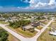 Aerial view of property including surrounding neighborhood with tree coverage, roads and cloud-filled skies at 7247 Brookhaven Ter, Englewood, FL 34224
