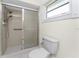 Bathroom showcasing shower with glass door, toilet, and tile flooring at 7247 Brookhaven Ter, Englewood, FL 34224