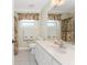 Bright bathroom featuring a modern vanity, sink, and a large mirror, complemented by patterned window coverings at 7247 Brookhaven Ter, Englewood, FL 34224