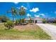 Charming single Gathering home featuring an attached garage, neutral paint, green grass and mature trees at 7247 Brookhaven Ter, Englewood, FL 34224