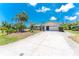 Charming single Gathering home featuring an attached garage, neutral paint, green grass and mature trees at 7247 Brookhaven Ter, Englewood, FL 34224