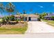 Charming single Gathering home featuring an attached garage, neutral paint, green grass and mature trees at 7247 Brookhaven Ter, Englewood, FL 34224