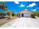 Charming single Gathering home featuring an attached garage, neutral paint, green grass and mature trees at 7247 Brookhaven Ter, Englewood, FL 34224