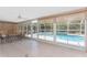 Enclosed patio with tile flooring, ceiling fan, and views of the sparkling pool through large windows at 7247 Brookhaven Ter, Englewood, FL 34224