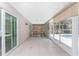 Bright sunroom features tile flooring and view of the sparkling pool through large windows and sliding doors at 7247 Brookhaven Ter, Englewood, FL 34224