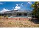 Exterior of a screened-in pool and patio area with a beautiful lawn and landscaping at 7247 Brookhaven Ter, Englewood, FL 34224