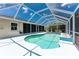 A lovely screened-in pool and patio area that features an in-ground pool, decking, and landscaping at 7247 Brookhaven Ter, Englewood, FL 34224