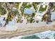 Aerial view of beach homes with a pool, green roof, and beachfront access at 7420 Manasota Key Rd, Englewood, FL 34223