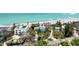 Aerial view showcasing the neighborhood, including a beach house with landscaping and a glimpse of the ocean at 7420 Manasota Key Rd, Englewood, FL 34223
