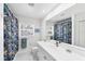 Bright bathroom with a white sink, mirror, white tiled floor and colorful shower curtain at 7420 Manasota Key Rd, Englewood, FL 34223