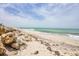 Picturesque beach with sandy shores, clear waters, and a natural rock formation at 7420 Manasota Key Rd, Englewood, FL 34223