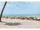 Scenic beachfront featuring sandy shores, turquoise waters, and a protective rock barrier at 7420 Manasota Key Rd, Englewood, FL 34223