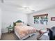 Bright bedroom featuring a patterned comforter, ceiling fan, and a window offering a peek of the beach at 7420 Manasota Key Rd, Englewood, FL 34223