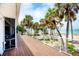 Beautiful outdoor deck overlooks a sandy beach with swaying palm trees and calming blue ocean views at 7420 Manasota Key Rd, Englewood, FL 34223