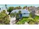 Coastal home featuring lush tropical landscaping, a gray roof, and a serene view of the beach and ocean at 7420 Manasota Key Rd, Englewood, FL 34223