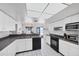 Bright kitchen featuring white cabinets, dark countertops and views of the dining room and ocean at 7420 Manasota Key Rd, Englewood, FL 34223