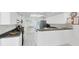 Bright kitchen featuring white cabinets, countertops, and stainless steel refrigerator and white tiled floor at 7420 Manasota Key Rd, Englewood, FL 34223