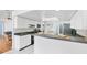 Bright kitchen featuring white cabinets, countertops, and stainless steel refrigerator and white tiled floor at 7420 Manasota Key Rd, Englewood, FL 34223