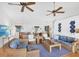 Spacious living room featuring ceiling fans, wicker furnishings, hardwood floors, and beach decor at 7420 Manasota Key Rd, Englewood, FL 34223