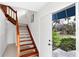 Inviting home entry with wooden staircase and view of greenery outside the doorway at 7420 Manasota Key Rd, Englewood, FL 34223