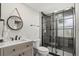 Modern bathroom with sleek black-framed glass shower, updated vanity, and stylish round mirror at 7530 Whitcomb St, Englewood, FL 34223