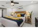 Well-lit bedroom featuring a woven headboard, ceiling fan, and neutral decor with bright yellow accents at 7530 Whitcomb St, Englewood, FL 34223