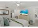 Bright bedroom with a ceiling fan, TV, and serene beach view on the screen at 7530 Whitcomb St, Englewood, FL 34223