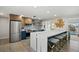 Bright kitchen with stainless steel appliances, a large island with seating, and a view of the pool at 7530 Whitcomb St, Englewood, FL 34223