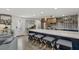 Open kitchen featuring a large island with seating, stainless steel appliances, and stylish backsplash and decor at 7530 Whitcomb St, Englewood, FL 34223