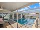 Inviting pool area with screened enclosure, poolside bar, and seamless indoor-outdoor flow for entertainment at 7530 Whitcomb St, Englewood, FL 34223