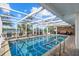 Inviting pool area with a screened enclosure, poolside seating, and lush palm trees for a tropical oasis at 7530 Whitcomb St, Englewood, FL 34223