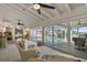 Bright sunroom with white ceiling, tiled floor, stylish furniture and view of outdoor pool at 7530 Whitcomb St, Englewood, FL 34223