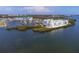 Aerial view of stunning waterfront condos surrounded by water, boats, and mangroves at 8005 Bay Pointe Dr, Englewood, FL 34224