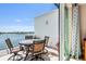 A charming outdoor balcony with a dining table and stunning views of the tranquil water and coastline at 8005 Bay Pointe Dr, Englewood, FL 34224