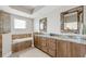 Luxurious bathroom featuring dual sinks, granite countertops, and a separate soaking tub at 8005 Bay Pointe Dr, Englewood, FL 34224