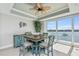 Cozy dining area with blue furniture overlooking the beautiful waterfront and outdoor patio at 8005 Bay Pointe Dr, Englewood, FL 34224