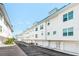 Modern white townhomes with blue accents and well-maintained landscaping along a quiet street at 8005 Bay Pointe Dr, Englewood, FL 34224