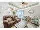 Bright living room boasts comfortable seating, ceiling fan and sliding glass doors to a waterfront view at 8005 Bay Pointe Dr, Englewood, FL 34224
