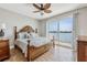 Tranquil main bedroom featuring a king bed, water view, wood floors, and ceiling fan at 8005 Bay Pointe Dr, Englewood, FL 34224