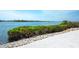 A waterfront property with lush greenery, rock accents, and serene water views at 8005 Bay Pointe Dr, Englewood, FL 34224