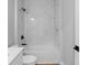 Elegant bathroom showcasing marble-look tile, a white bathtub, and sleek black fixtures for a modern, luxurious feel at 8105 Antwerp Cir, Port Charlotte, FL 33981