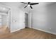 Spacious bedroom with wood-look flooring, closet, ceiling fan, and view to the hall at 8105 Antwerp Cir, Port Charlotte, FL 33981