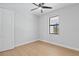 Bright bedroom with wood-look floors, neutral walls, ceiling fan, and large window overlooking the exterior at 8105 Antwerp Cir, Port Charlotte, FL 33981