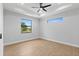 Bright, minimalist bedroom with wood floors, lots of light, and ceiling fan at 8105 Antwerp Cir, Port Charlotte, FL 33981